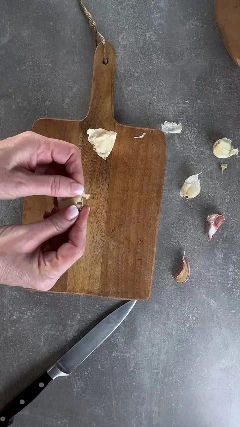 Peel garlic by classic crush method with knife. Overhead. Stock Footage 297710151
