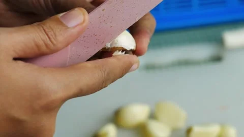 Peel the garlic using a knife. Stock-Footage 294196632