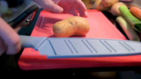 Peel the potato with a peeler Stock Footage 124680403