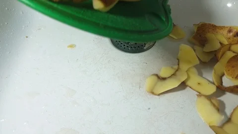 Peel from potatoes on a cutting board in the kitchen sink. Stock Footage 107565078