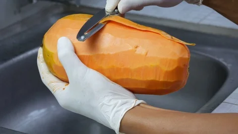 Peel the ripe papaya with a sharp knife Stock Footage 89225286