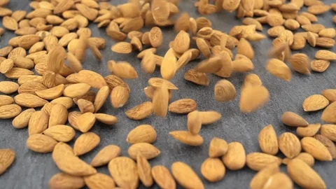 Peeled almonds falling on gray stone background Stock Footage 88813998