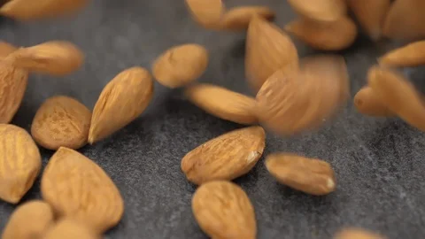 Peeled almonds falling on gray stone background, close-up Stock-Footage 88814136