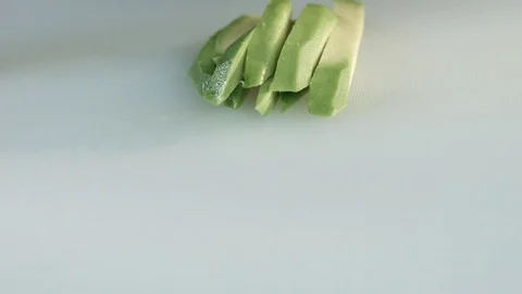 Peeled avocado cut with a knife into slices closeup Stock Footage 80594821