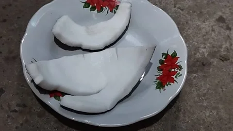 Peeled coconut is on a white plate Stock Footage 219214752