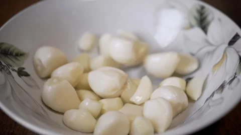 Peeled Garlic Cloves Falling Into White Bowl In Slow Motion Stock Footage 330117282