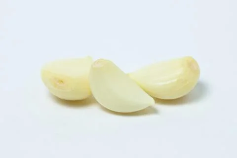 Peeled garlic on a white background.  Stock Photos