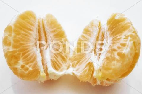 Peeled, halved clementine Stock Photos