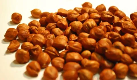Peeled kernel hazelnuts in bulk close up in bulk as background Stock Photos