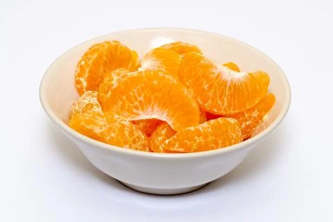 Peeled mandarin orange in a bowl on white background Stock Photos