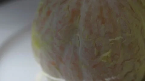 Peeled orange rotating on a plate Stock Footage 172334564