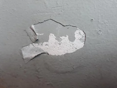Peeled paint layer on grey wall Stock Photos