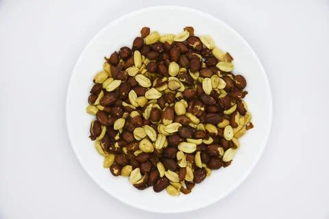 Peeled peanut kernels on a white plate. Delicious nuts. Peeled peanuts. Foto stock
