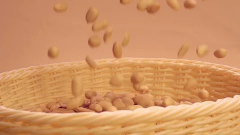 Peeled Peanuts fall into a beige basket in slow motion Stock Footage 76894409