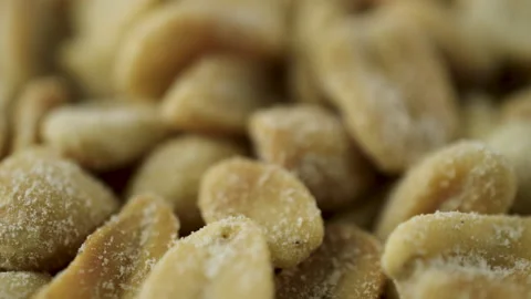 Peeled peanuts in powder rotate on the surface. Close up view Stock Footage 142036461