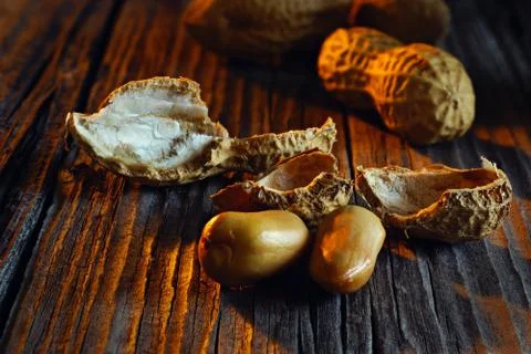 Peeled peanuts with shells in the background of vintage board Stock-Fotos