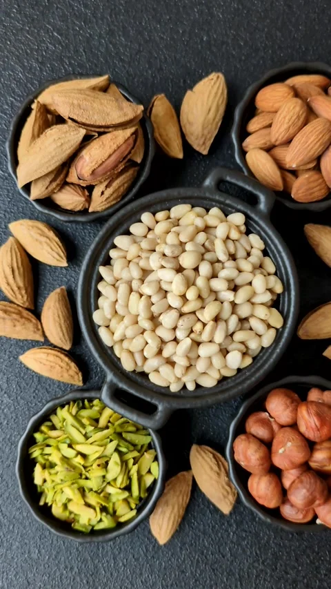 Peeled pine nuts in a bowl on a dark concrete background Stock Footage 305679271