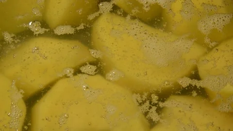 Peeled potato is being boiled Stockbeeldmateriaal 302229400