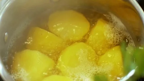 Peeled potatoes boiling in a pot of hot water Video stock 333875401