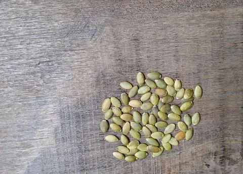 Peeled pumpkin seeds group on a rustic wooden background Stock Photos