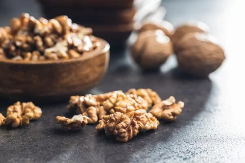 Peeled walnut kernels on black table. Stock Photos