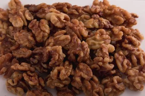 Peeled walnuts background close-up on white plate Stock Photos