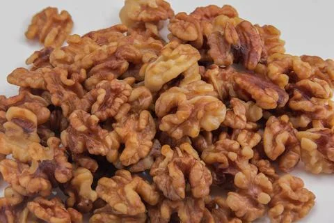 Peeled walnuts background macro on white ceramic plate Foto stock