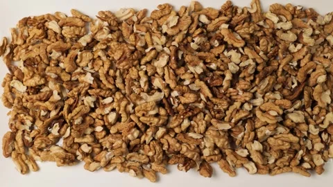 Peeled walnuts on a white plate moving slowly Stock Footage 344604740