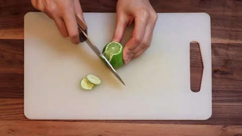 Peeling and Cutting Fresh Lime on Cutting Board in Kitchen-Horizontal Stock Footage 333788199