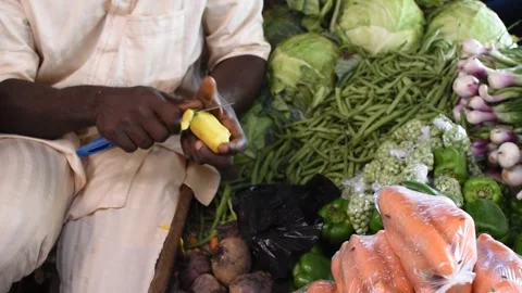 Peeling and cutting fresh vegetables at a local market stall 動画素材 325904879