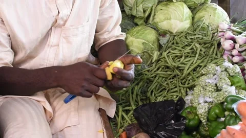 Peeling and cutting fresh vegetables at a local market stall 動画素材 325904989