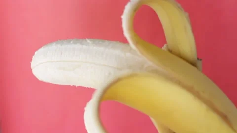 Peeling banana on red background Stock Footage 115637930