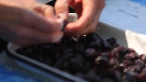 Peeling black olives with both hands Stock Footage 133749049