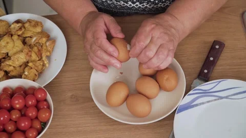 Peeling boiled eggs in bowl for Caesar salad preparation Stock Footage 328372982