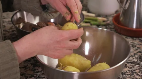 Peeling boiled potatoes by hand in the kitchen Vídeo Stock 331218545