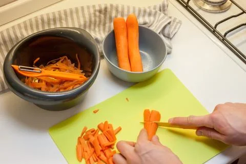 Peeling carrot at kitchen Stock Photos