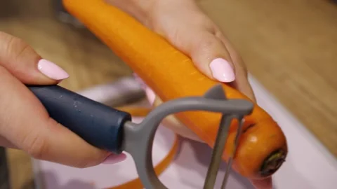 Peeling carrots in the kitchen Stockbeeldmateriaal 270492923