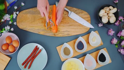 Peeling carrots with a vegetable peeler in the kitchen Video stock 252179962