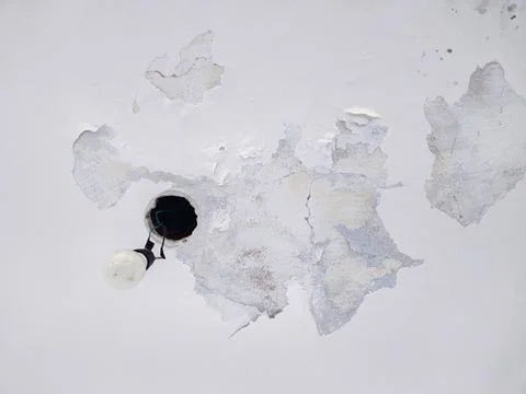 Peeling ceiling paint with exposed bulb Foto stock