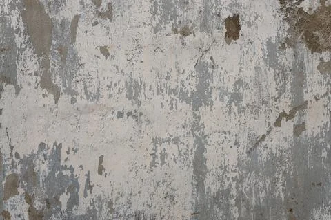 Peeling coating of old gray paint on a dirty concrete wall Foto stock