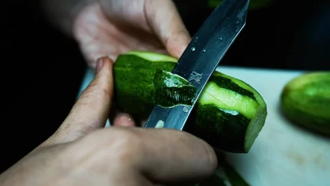 Peeling a Cucumber with a Knife, Close-up of hands peeling a cucumber with .. Video stock 304978491
