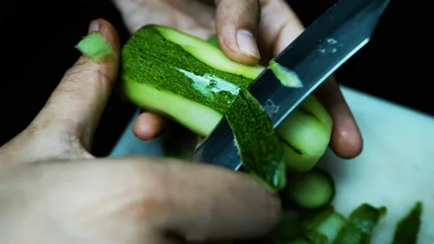 Peeling a Cucumber with a Knife, Close-up of hands peeling a cucumber with .. Stock Footage 304978554