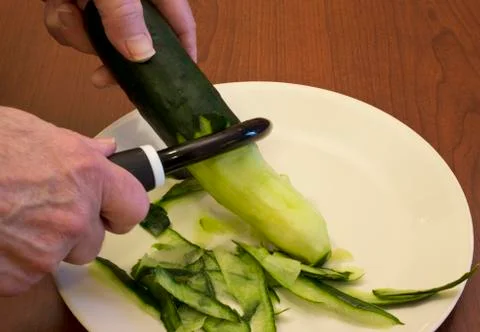 Peeling a cucumber 库存照片
