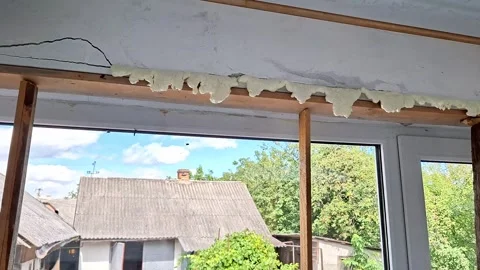 Peeling Deteriorated Foam Insulation Above a Window During Home Renovation Vídeos de archivo 346201410