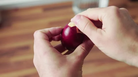 Peeling dyed easter egg shell by hand closeup first person view Stock Footage 332718397