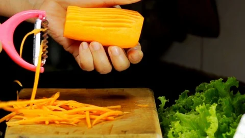 Peeling Fresh Carrot with Vegetable Peeler Stock Footage 130141609