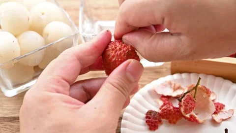 Peeling fresh lichees at horizontal composition Stock Footage 243959870