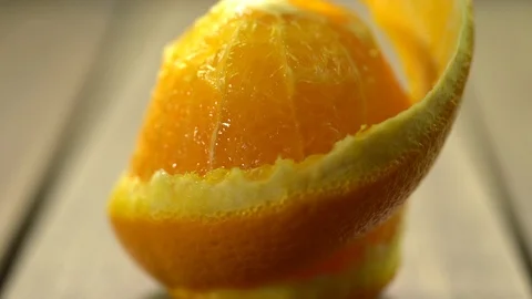Peeling fresh orange in slow motion scenic with wooden background Stock Footage 124123635