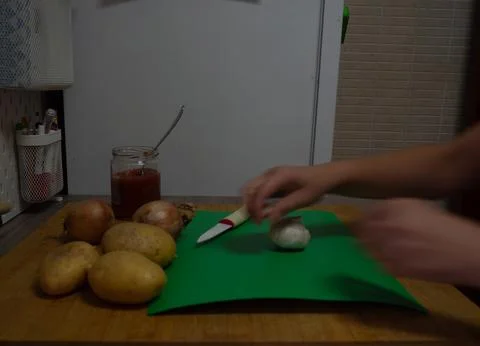 Peeling garlic in the kitchen Stock Photos