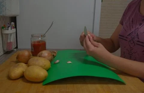 Peeling garlic in the kitchen Stock Photos